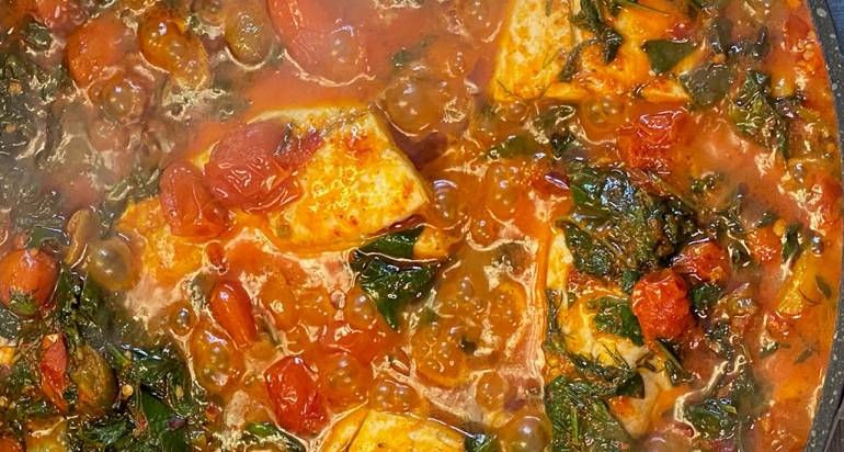 סיר דגים ברמונדי עם עגבניות, שום, זיתים וצמחי תבלין