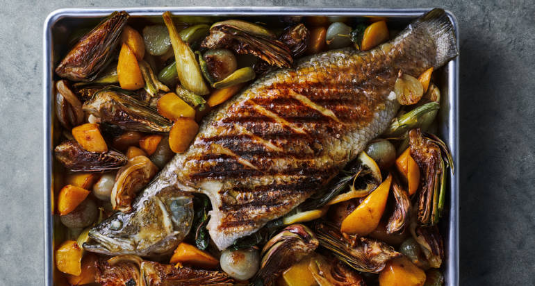 דג ברמונדי ישראלי שלם בתנור עם ארטישוק, גזרים ושומר ברוטב יין לבן